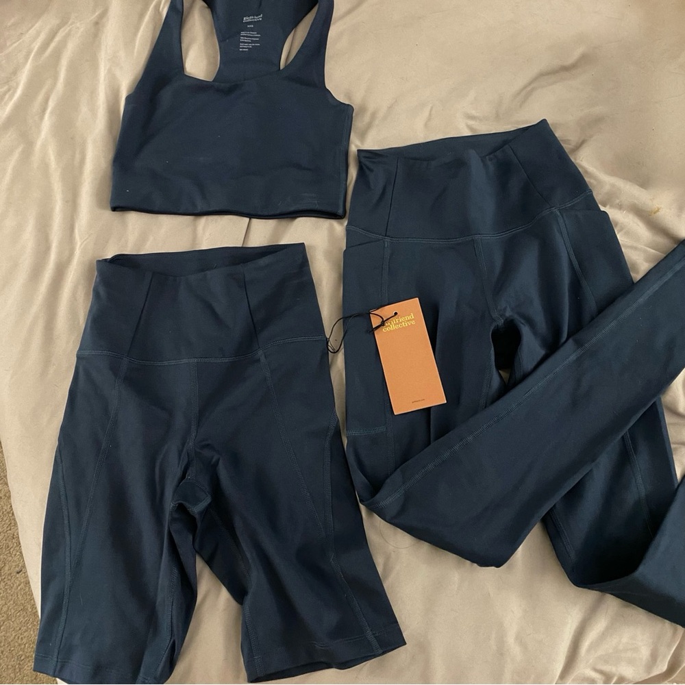 Girlfriend Collective navy blue sports bra , biker shorts and legging set